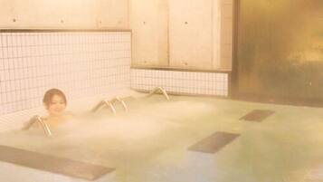 A hot tub with a tiled wall and a large door.