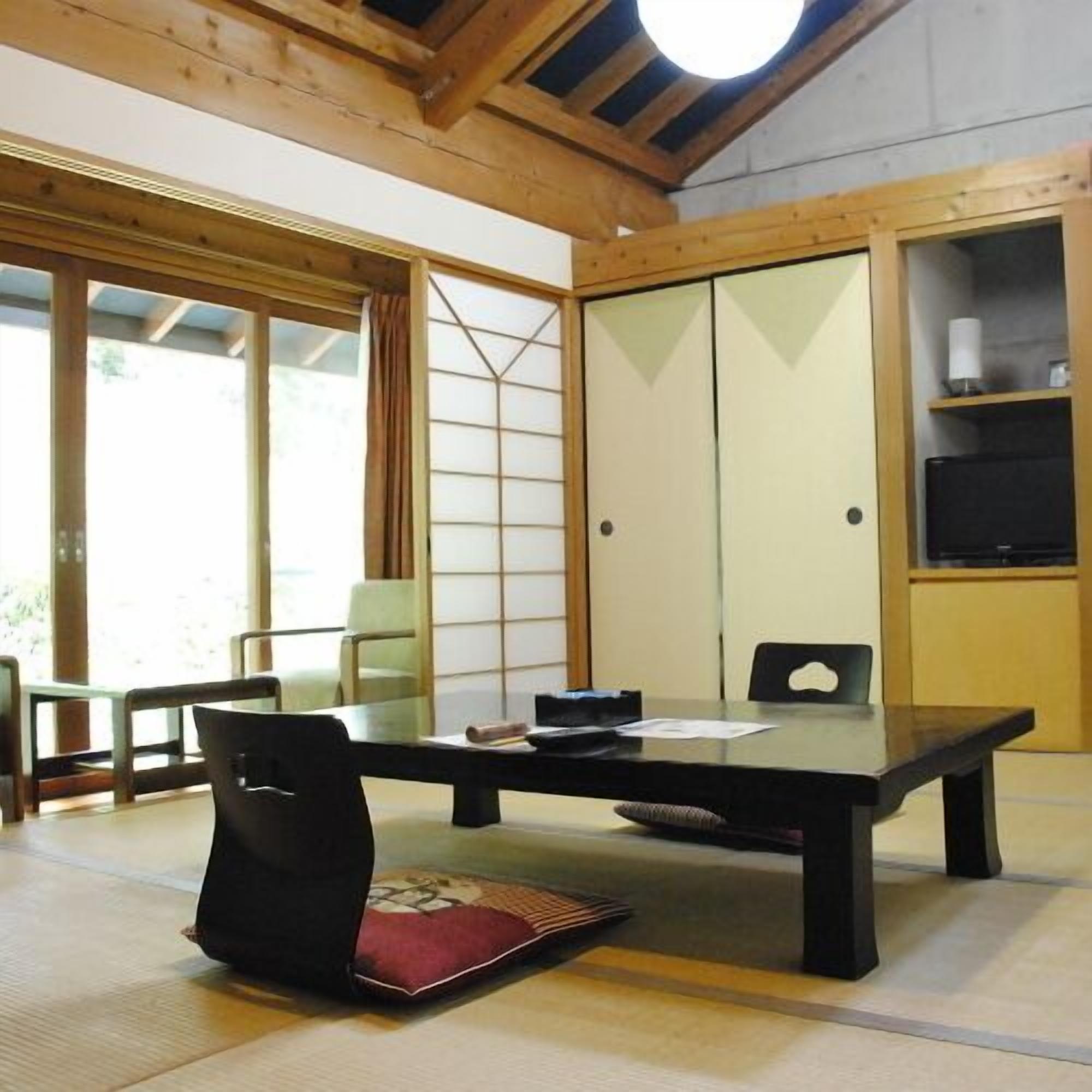 Een traditionele Japanse kamer met tatami vloerbedekking, een lage tafel en verschuifbare deuren.