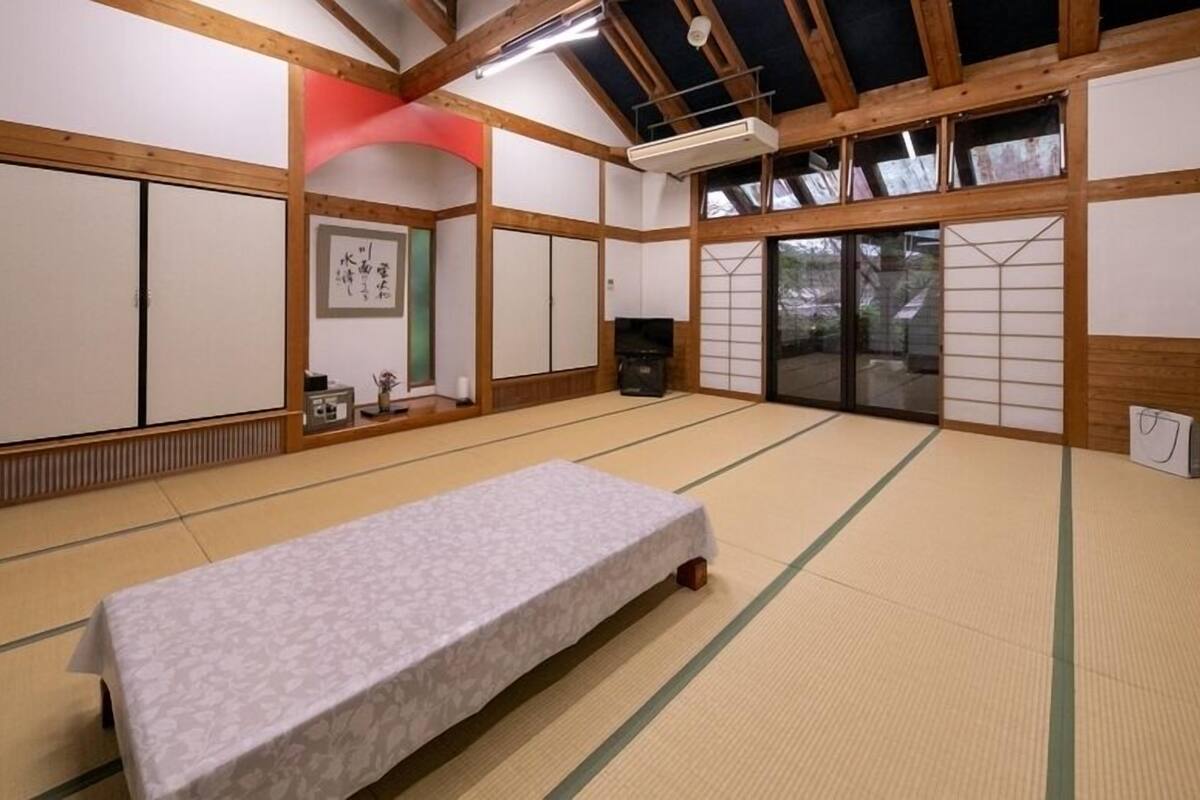 Una stanza con pavimento in tatami, un futon, porte scorrevoli e un'estetica tradizionale giapponese.
