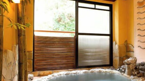 A spa room with a hot tub, bamboo decor, and a view through a large window.