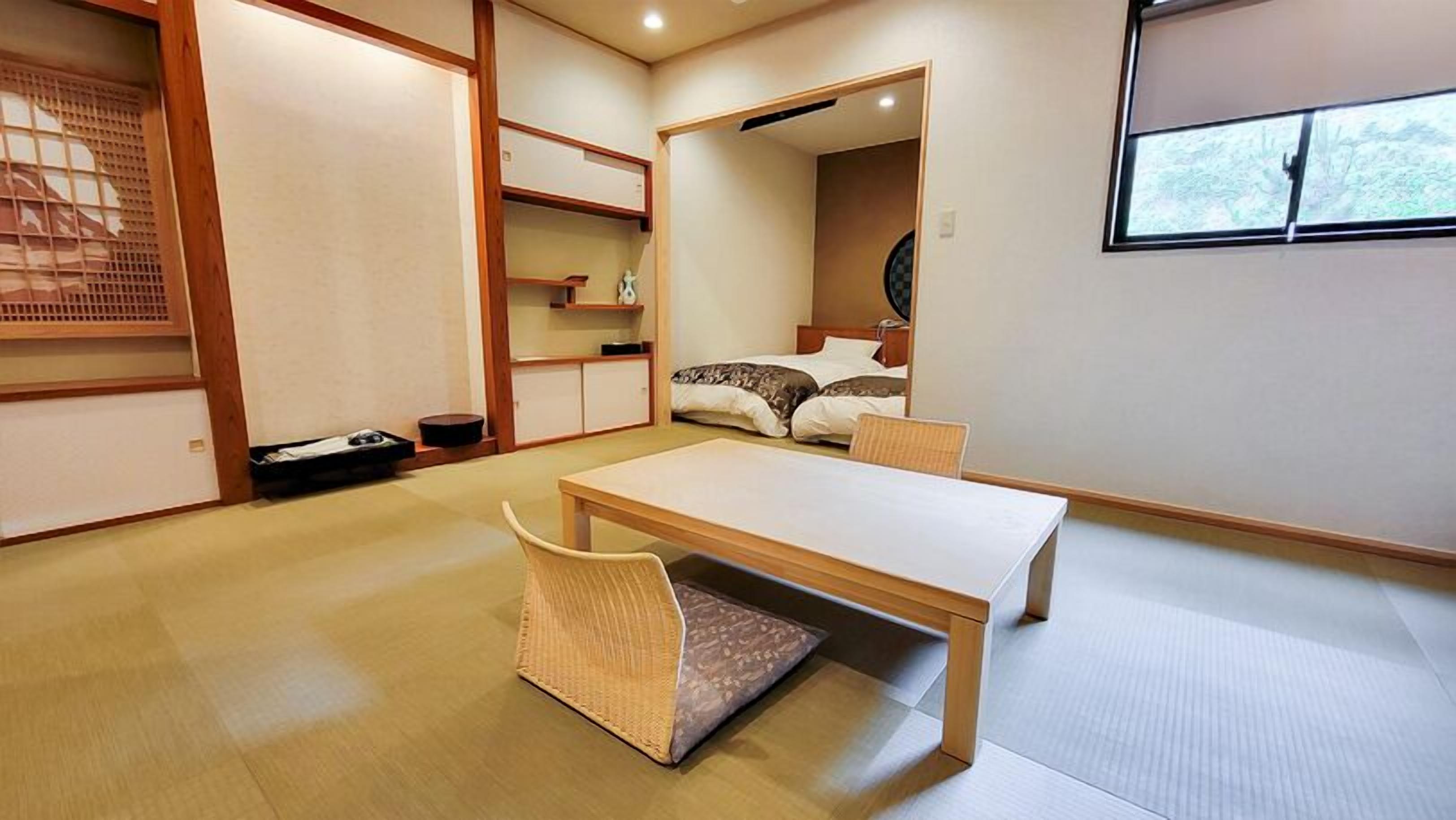 Una habitación de estilo japonés tradicional con suelo de tatami, una mesa baja, una silla y una cama con futón.