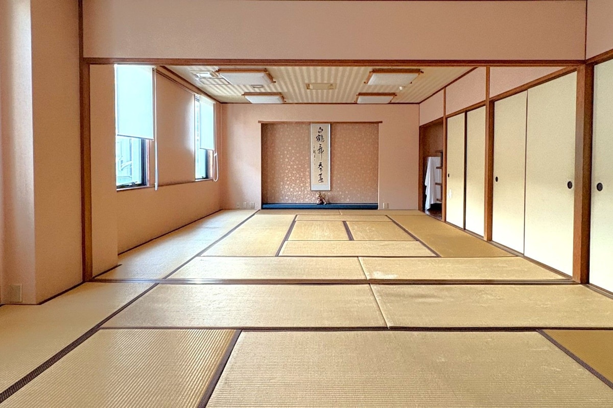 Una habitación japonesa tradicional con suelo de tatami, puertas correderas y un mamparas shoji.