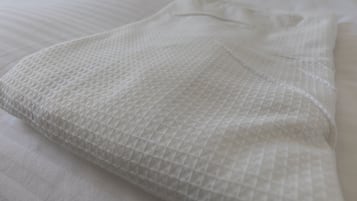 A neatly folded white bedspread with a textured pattern.