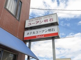 Señal para un hotel de negocios con texto en japonés y la palabra 'Tabist' en inglés.