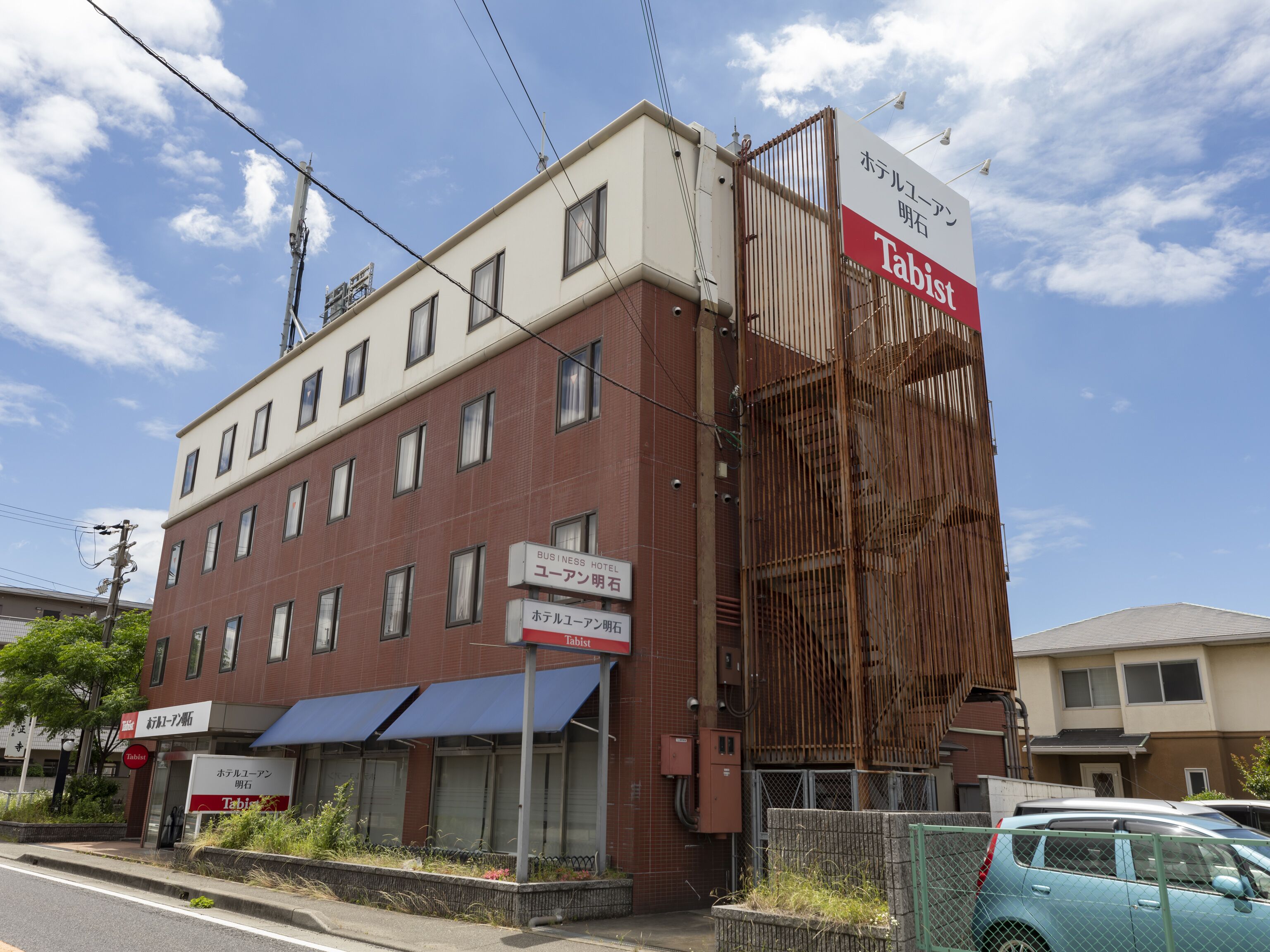 A multi-story building with signs for 'Hotel Yuruan' and 'Tabist'.