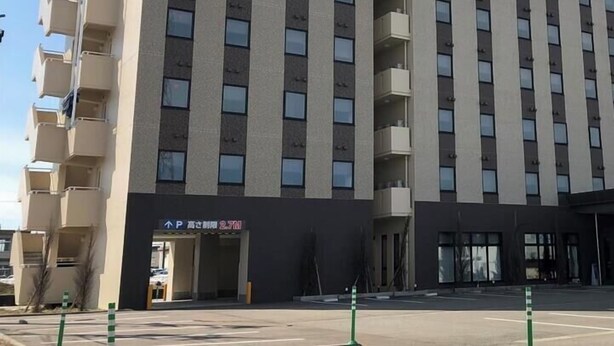 A multi-story hotel with a modern design, featuring a prominent 'P' sign indicating parking availability. - Hotel Park Inn Tonami Inter (Tonami)