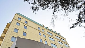 A multi-story building with a flat roof and multiple windows.
