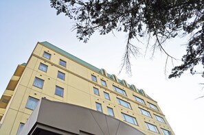 A multi-story building with a flat roof and multiple windows.