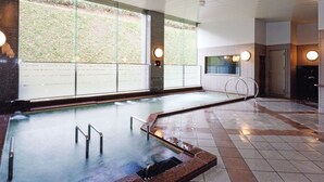 A modern indoor swimming pool with clear glass walls, a tiled floor, and a steam feature. - Shibetsu Inn Suigetsu (Shibetsu)
