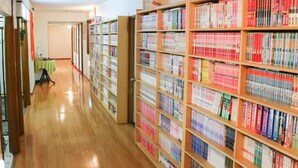 A library with bookshelves on both sides of a wooden floor. - Okuyama (Shinjo)