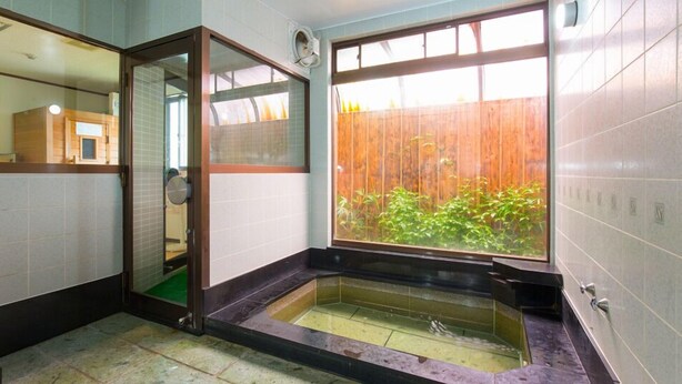 A bathroom with a glass door, a window, and a small bathtub. - Okuyama (Shinjo)