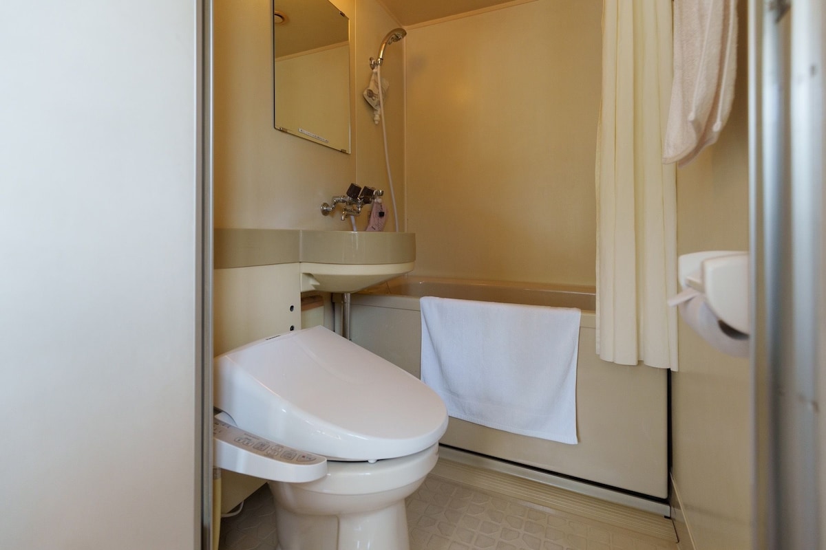 A bathroom with a toilet, sink, and shower.