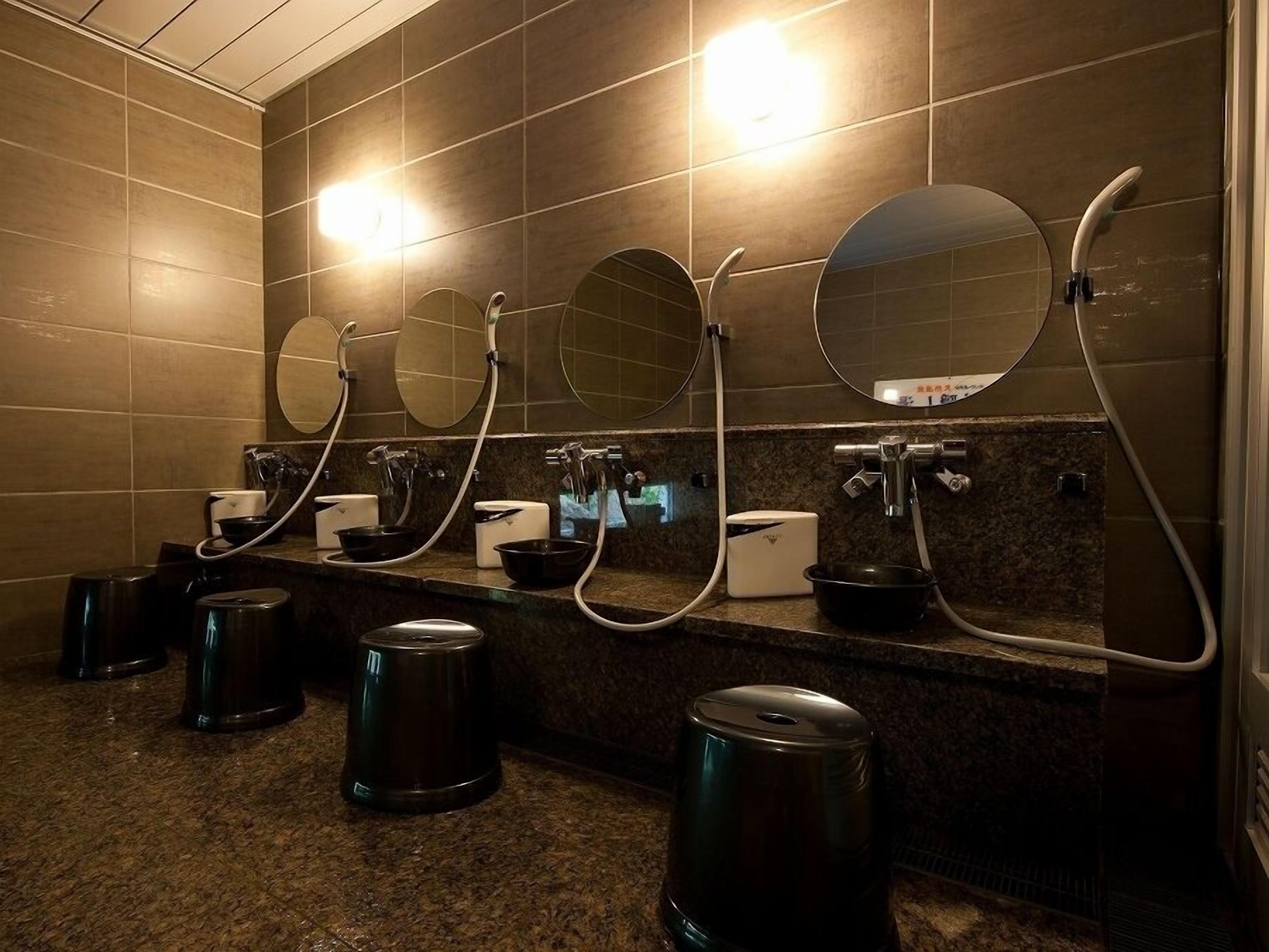 Des toilettes publiques équipées de plusieurs lavabos, de miroirs et de poubelles.