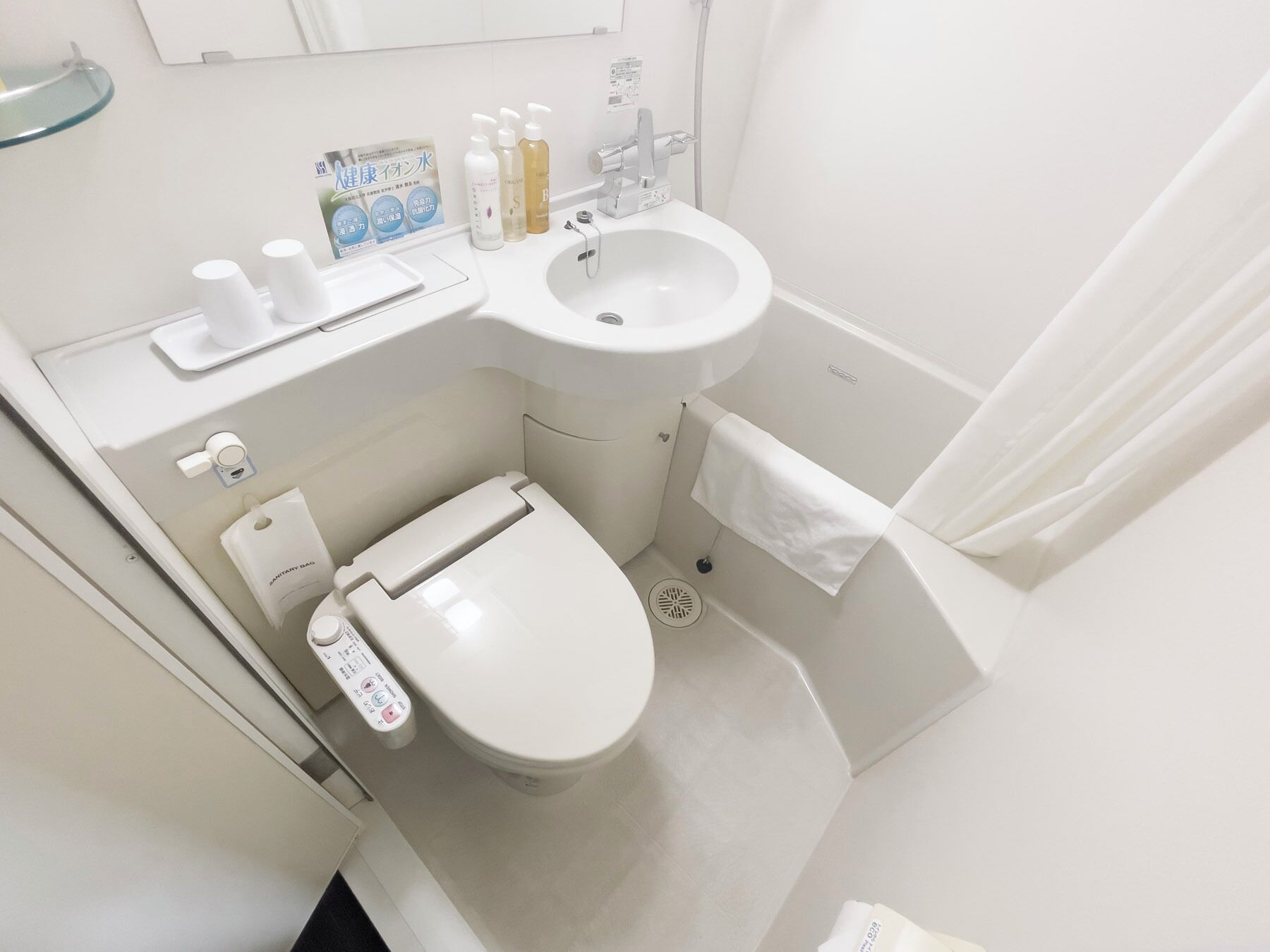 Une petite salle de bain moderne comprenant des toilettes, un lavabo et un espace douche.