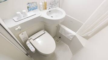 Une petite salle de bain moderne comprenant des toilettes, un lavabo et un espace douche.