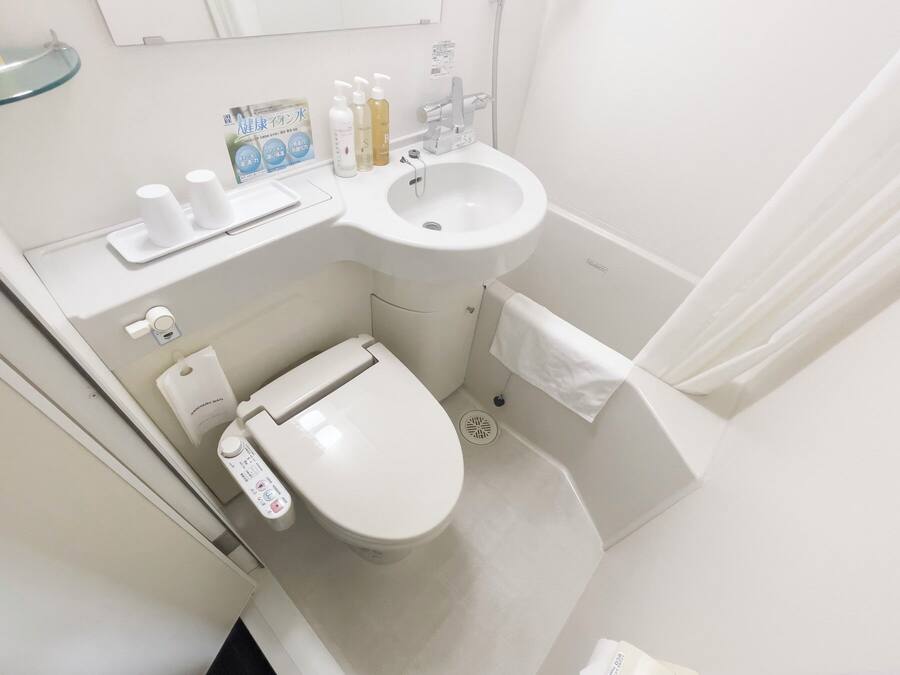 Une petite salle de bain moderne comprenant des toilettes, un lavabo et un espace douche.