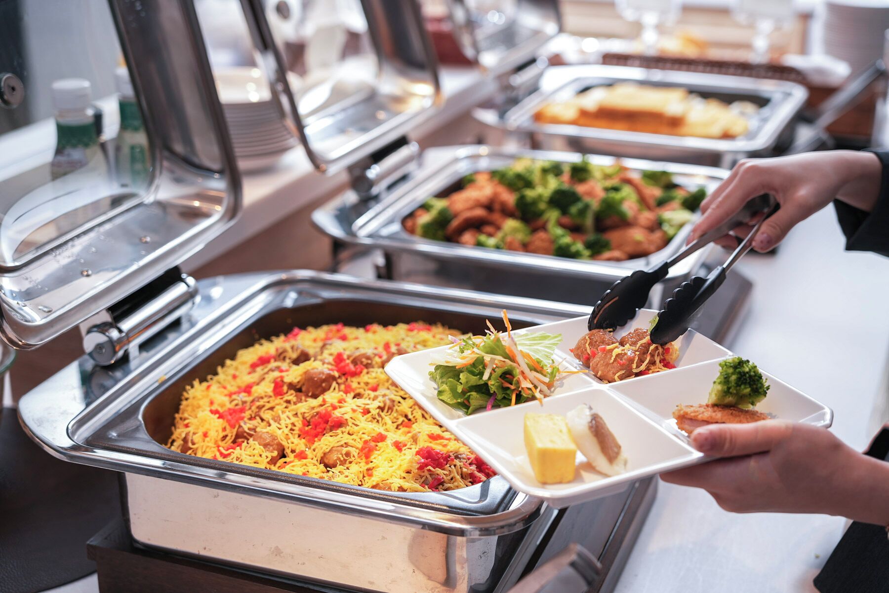 A buffet with various dishes including rice, meatballs, and salads.