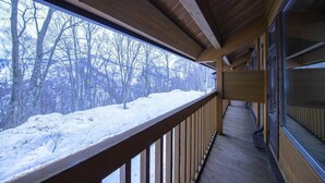 Un balcón de madera con vistas a un paisaje nevado.