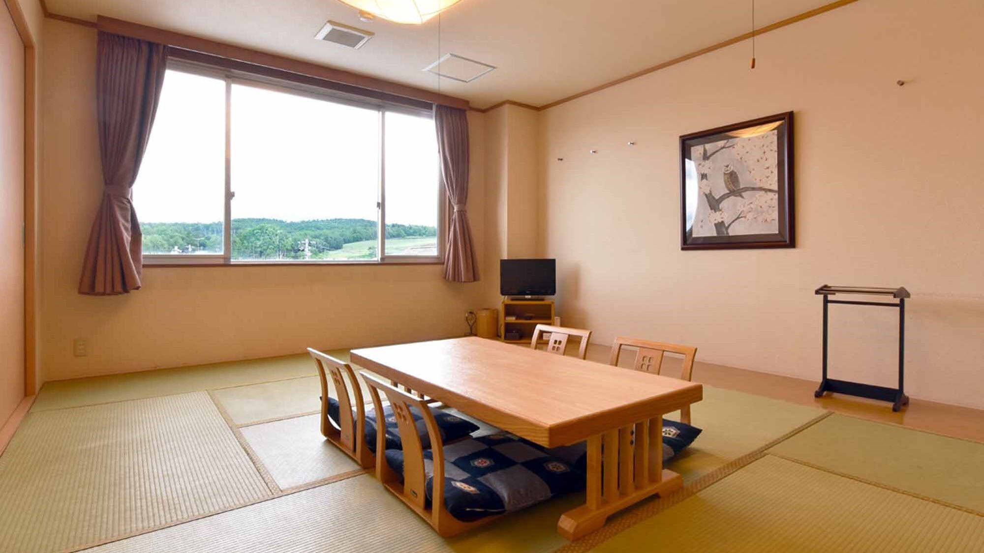 Une pièce avec des tatamis, une table en bois, des chaises, un téléviseur et un tableau encadré au mur.