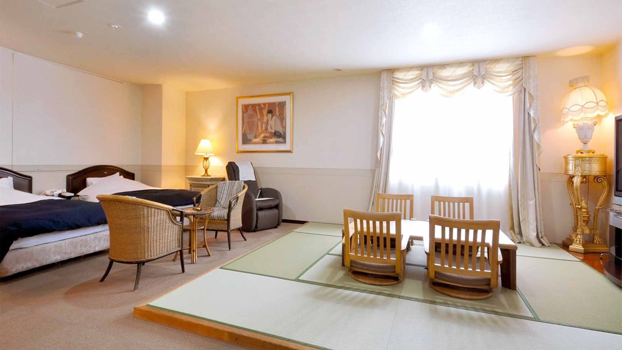 A hotel room with a bed, two chairs, a small table, a lamp, a painting on the wall, and a window with curtains.