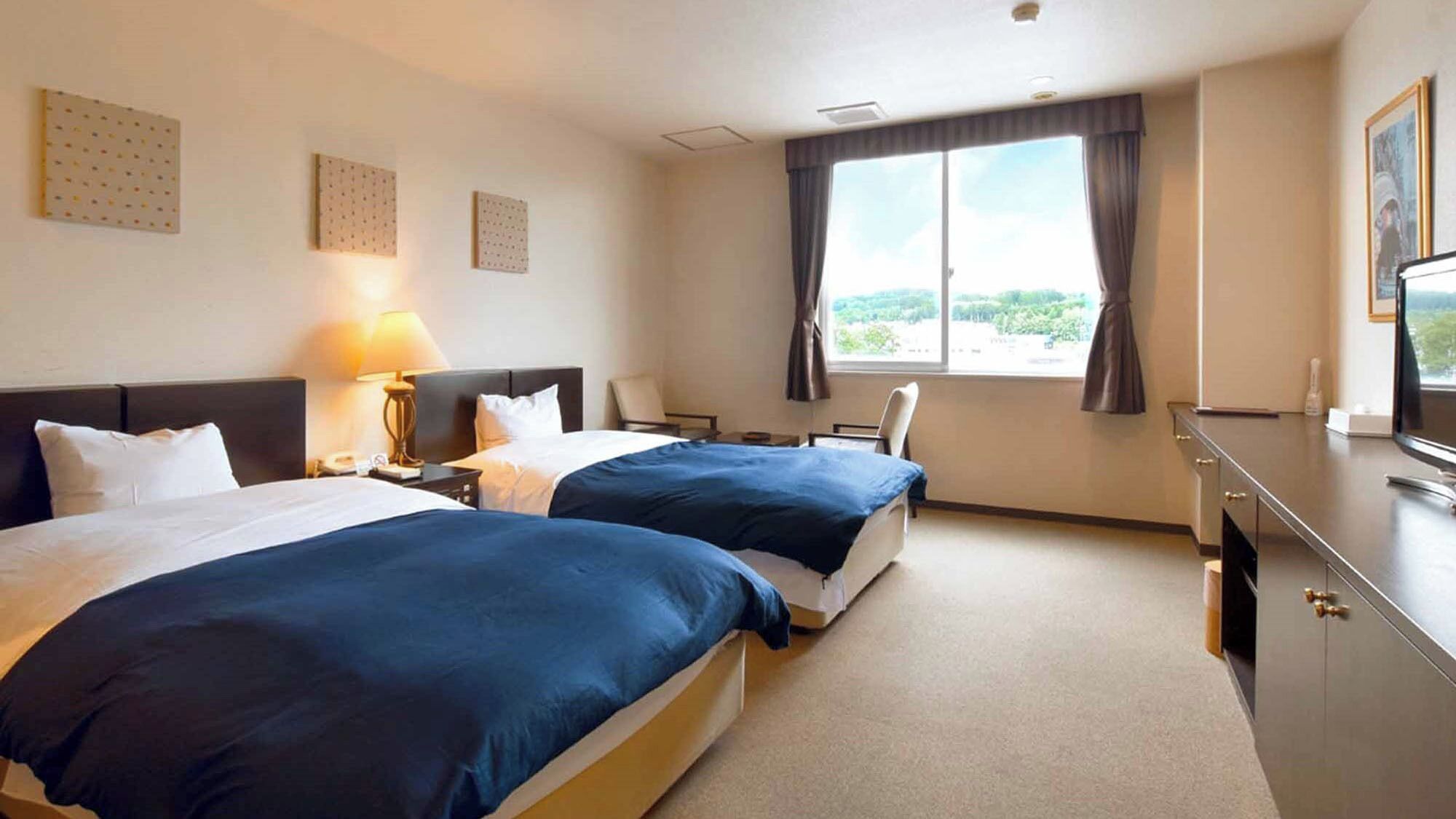 A hotel room with two beds, a desk, a chair, a TV, and a window with a view.