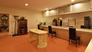 A room with a dining table, chairs, a cabinet, a mirror, and a clock on the wall.