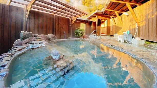 Una baita in legno con piscina a rivestimento in pietra e un patio coperto.
