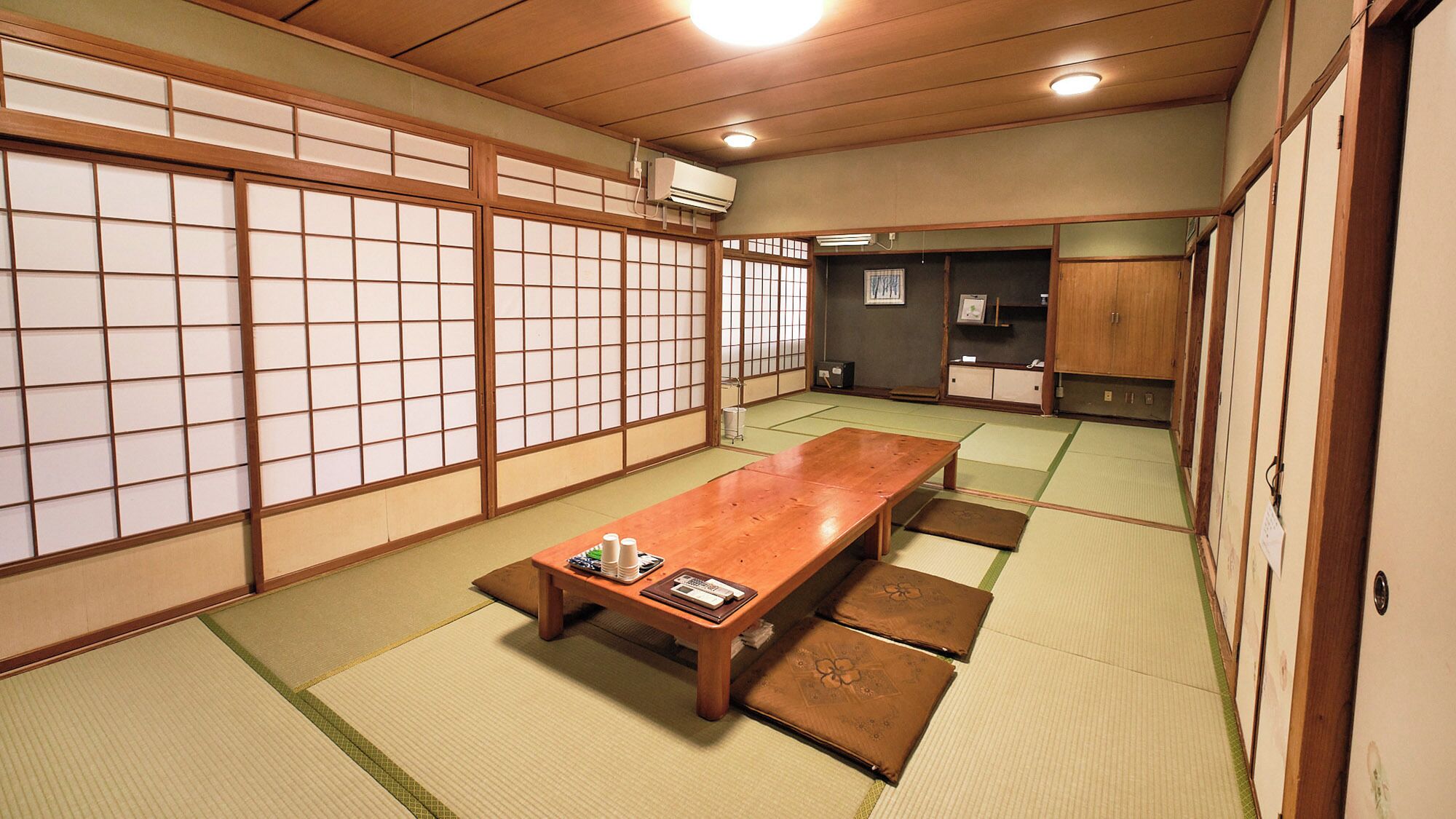 A traditional Japanese room with tatami flooring, a low wooden table, and sliding shoji doors.