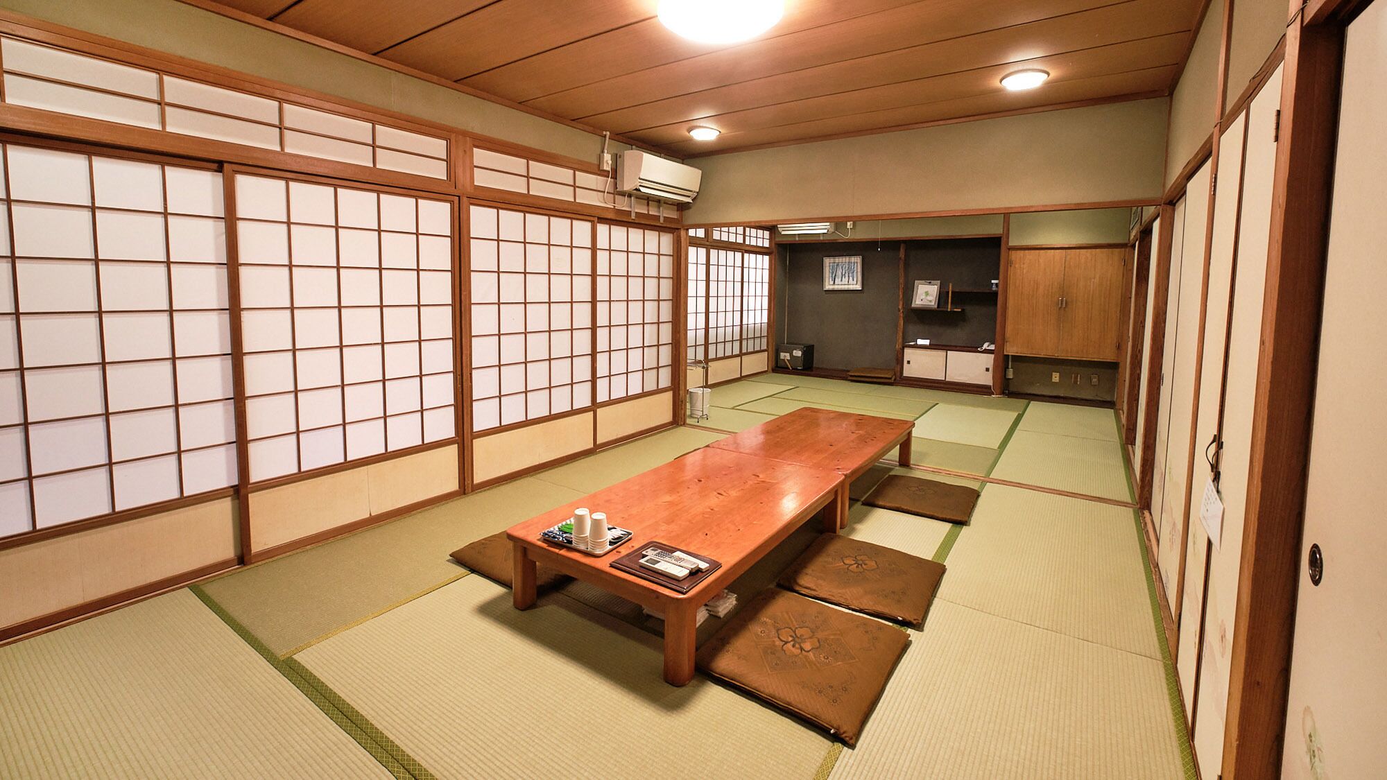 A traditional Japanese room with tatami flooring, a wooden table, and shoji screens.