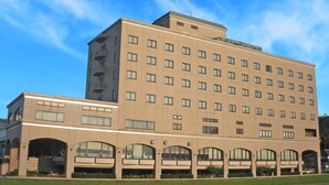 A multi-story hotel with a symmetrical facade, large windows, and a flat roof.