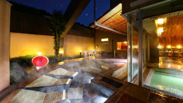 A hot tub area with steam rising, surrounded by a wooden deck and a glass enclosure. - Ooedo Onsen Monogatari Kimitsu no Mori (Kimitsu)