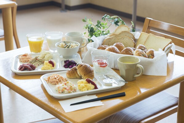 A breakfast tray with eggs, sausages, and bread on a wooden table. - Life Inn Katsuta Station West (Hitachinaka)