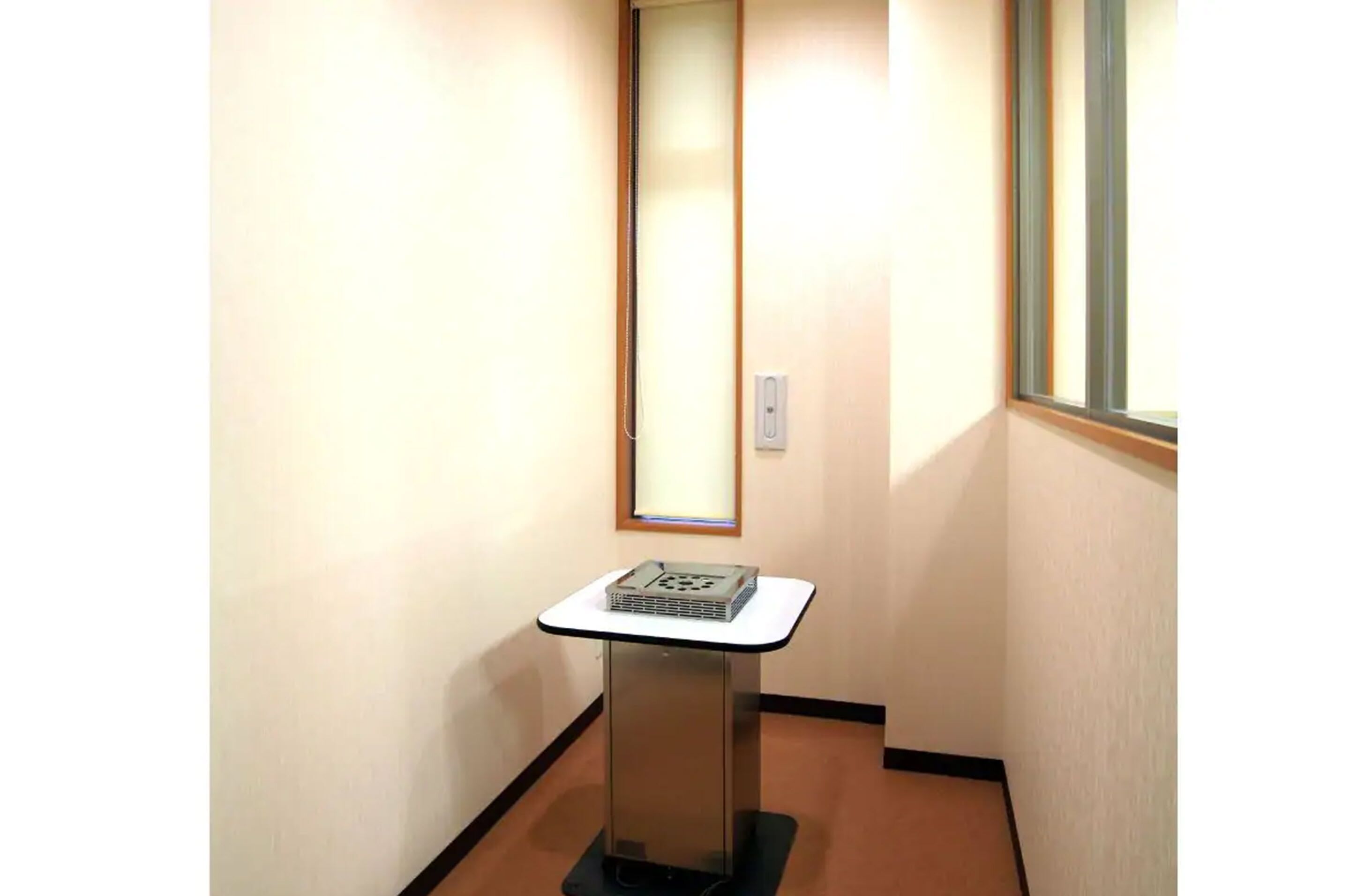 A narrow hallway with a small table and a projector screen on a stand.