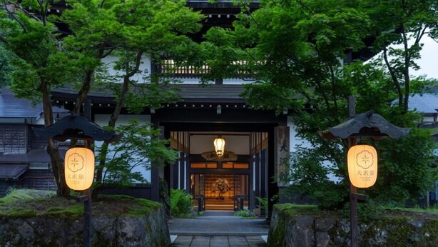 Une entrée de bâtiment japonais traditionnelle, avec une lanterne et une enseigne.