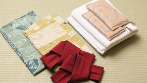 A neatly arranged set of fabrics and towels on a textured surface.