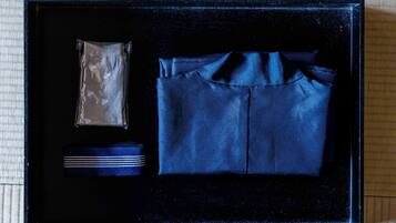 A black box containing a blue shirt, a striped tie, and a small packet.
