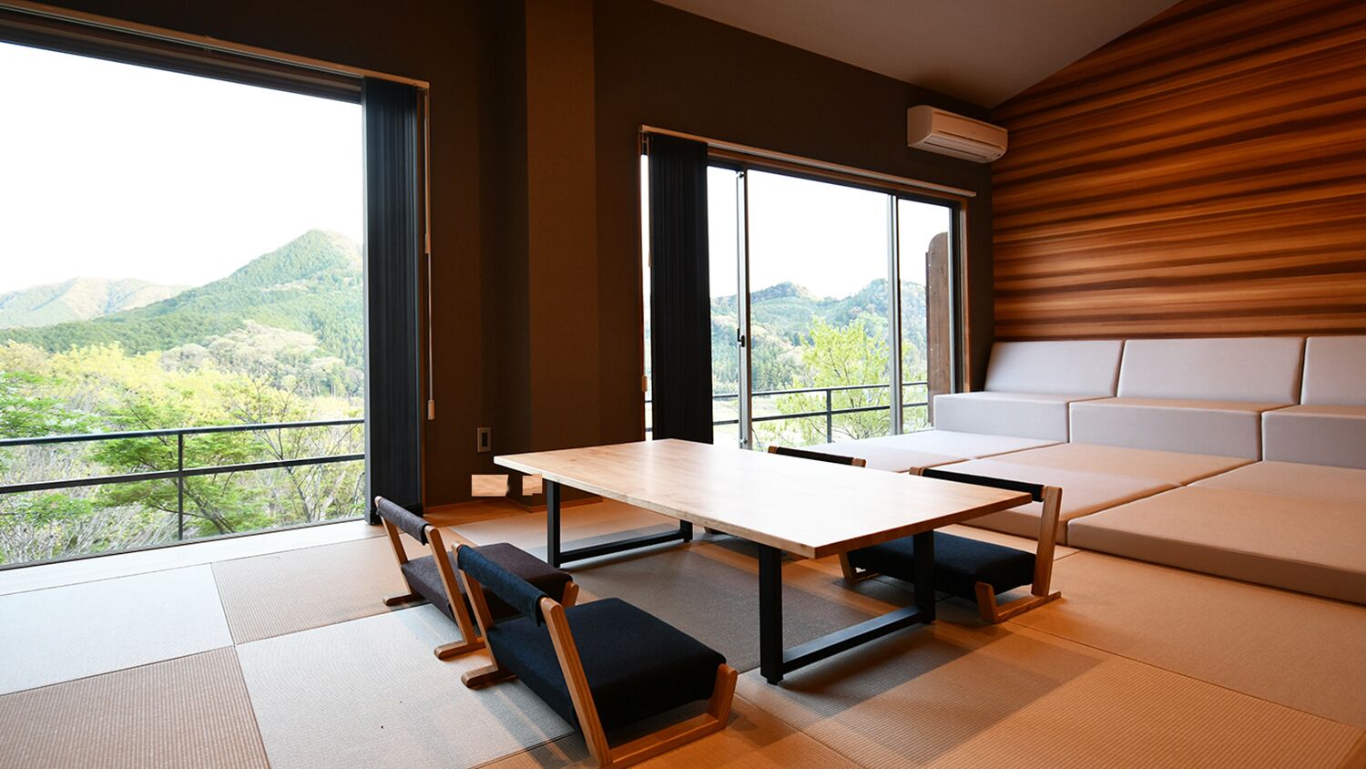 A modern room with tatami flooring, a low table, and a sofa.