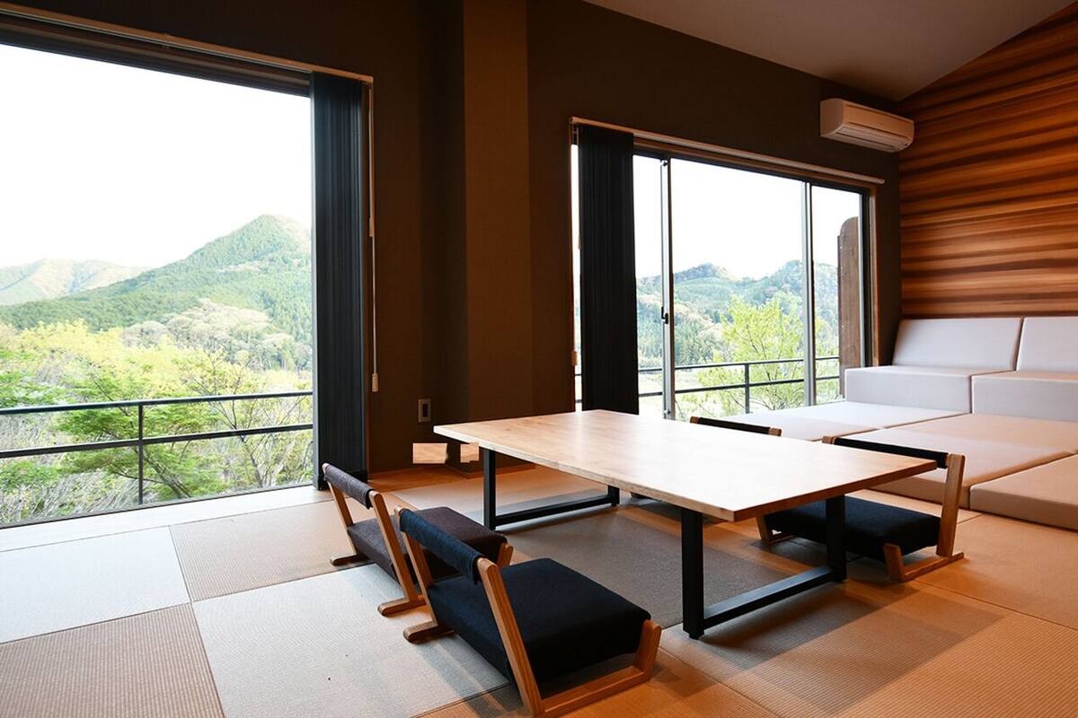 Une pièce moderne avec un sol recouvert de tatamis, une table basse et un canapé.