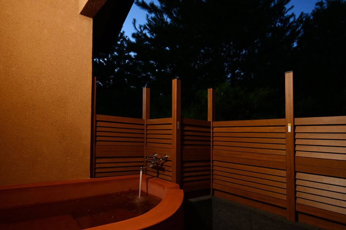 Un espace spa comprenant un jacuzzi, des murs recouverts de lambris en bois et un robinet en métal.