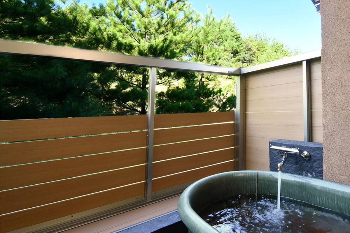 Un espace spa comprenant un jacuzzi, un mur avec des lambris en bois et un mur en pierre.