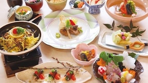 A variety of dishes arranged on a table, including a bowl of soup, a plate with vegetables, and a dish with a decorative flower. - Sun Green Kikugawa (Shimonoseki)