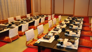 A conference room with multiple tables set for a meal, each with a variety of dishes and bowls. - Seishohtei Shirasuna (Shirako)