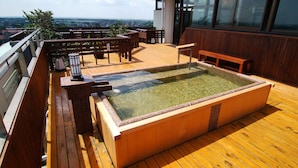 A wooden deck with a hot tub, seating area, and a view of the landscape. - Seishohtei Shirasuna (Shirako)