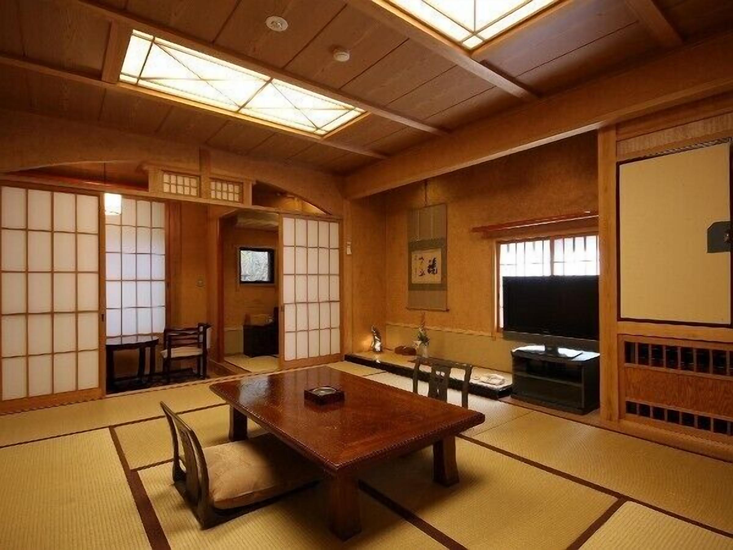 A traditional Japanese room with tatami flooring, a wooden table, and sliding doors.