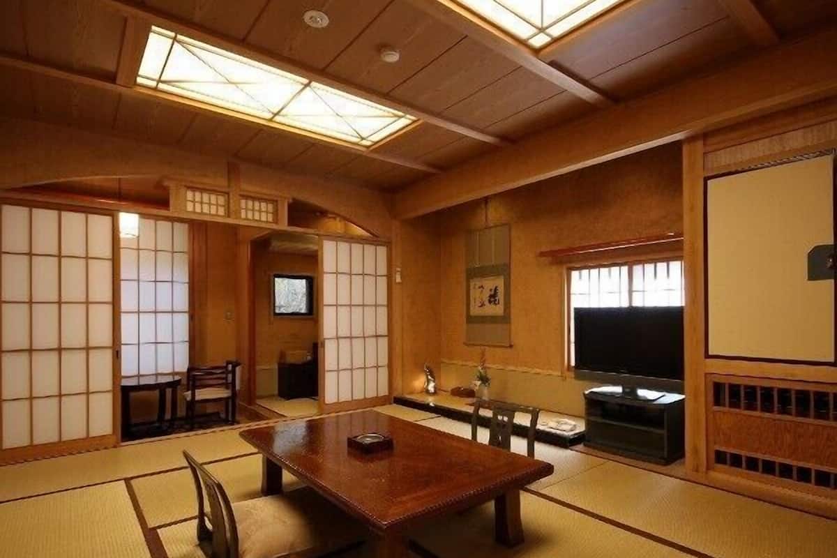Una habitación japonesa tradicional con suelo de tatami, una mesa de madera y puertas correderas.