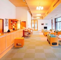 Un vestíbulo de hotel con mostrador de recepción, zona de estar y mostrador de check-in.