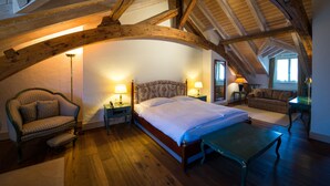 Une chambre à coucher avec un grand lit, un canapé, un fauteuil et une table.