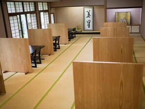 Una habitación japonesa tradicional con suelo de tatami, divisiones de madera bajas y un diseño de tatami.
