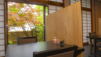 A traditional Japanese room with tatami flooring, a low table, and sliding doors.