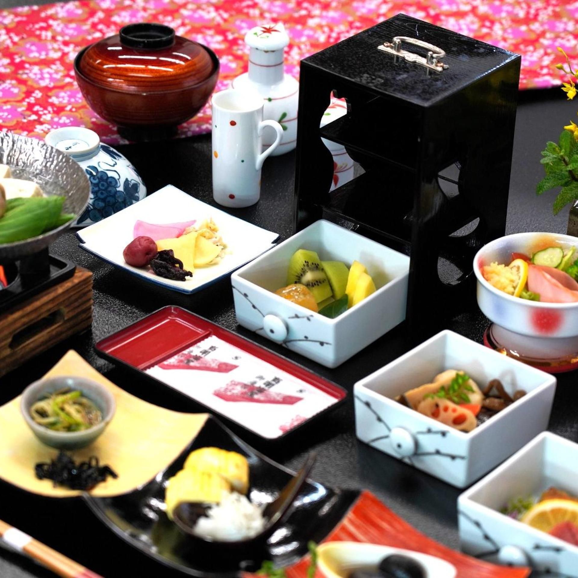 A variety of food items and dishes arranged on a table with a floral background.